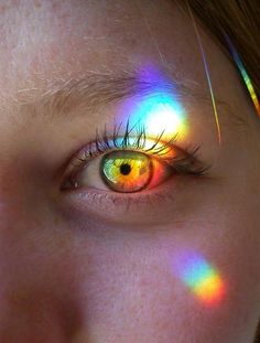 an image of a person's eye with colored light coming through it