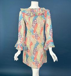 FEATURES: Original 1960s mini angel sleeve dress. Artistic, colorful pattern of different floral patterns.  Sheer with sewn in lining. Ruffle collar, high neck, low back, long sleeves with flared ruffles at the cuffs.  COLOR: Flax background with blue, green, red, purple. ERA: 1960s TAG: ILGWU tag FABRIC: feels like poly or cotton poly blend CLOSURE: zips up back CONDITION: Excellent, no issues to note  APPROX SIZE:  Small -MEASUREMENTS- Chest: 38" Waist: 33" Hip: 40"  Length (shoulder to hem): 34.5" *If package is marked delivered by the carrier, but you didn't receive it, you must report it to the carrier for them to investigate/try to re-deliver. All items I ship are insured. I do this for your benefit so you have a remedy for items lost/damaged in shipping.  *My items are used vintage Retro Mini Dress With Ruffles, Vintage Fitted Printed Mini Dress, Fitted Vintage Printed Mini Dress, Vintage Multicolor Ruffled Dresses, Multicolor Vintage Dress With Ruffles, Retro Multicolor Lined Mini Dress, Vintage Multicolor Floral Print Mini Dress, 1970s Multicolor Long Sleeve Dress, 1970s Style Multicolor Dress With Vintage Print