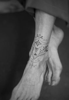 a woman's foot with a flower tattoo on the left side of her leg