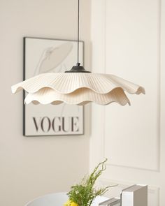 a white lamp hanging over a dining room table