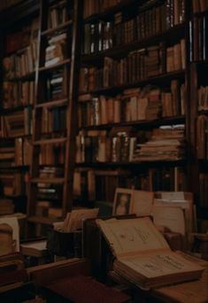 an old library with many books on the shelves and stacks of papers in front of them