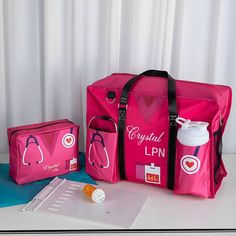 two pink medical bags sitting on top of a table