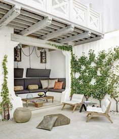 an outdoor living area with white walls and wooden furniture