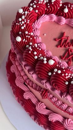 a heart shaped cake with pink frosting and white sprinkles