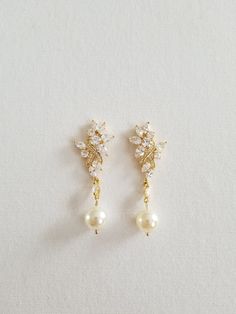 "Gorgeous sparkly cubic zirconia wedding earrings for the bride. Handcrafted with Swarovski pearls and high quality cubic zirconias. For pierced ears only. I do have other types of pearls available such as freshwater pearls and shell pearls that are in different shapes & sizes. Please contact for other options. ♥ SIZE: 2 1/8\" long x 3/4\" wide ♥ COLORS: Silver, Gold, Rose Gold ♥ PRODUCTION TIME: Ready to ship out in 1-2 business days ♥ IMPORTANT: Please be sure to read my policy section for Pearl-embellished Cubic Zirconia Drop Earrings, Pearl White Bridal Earrings With Pearl Drop, Cubic Zirconia Pearl Drop Earrings, Pearl Embellished Cubic Zirconia Wedding Earrings, Wedding Pearl Earrings With Sparkling Stones, Wedding Pearl Earrings With Sparkling Cubic Zirconia, Delicate Pearl Drop Earrings With Cubic Zirconia, Pearl White Cubic Zirconia Earrings For Wedding, Gold Diamond Earrings With Pearl Drop For Wedding