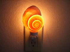 a light that is on the side of a wall with a snail lamp in it