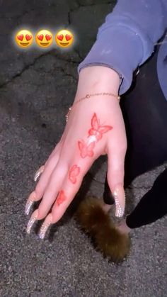 a woman's hand with red flowers painted on it and four emoticions