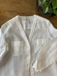 "Max Mara vintage boutique Linen tunic top V-neck button down Long sleeves Front pockets Side slits Sqare peal buttons Elegant relaxed wear 12\" side slits 100% Italian linen Brand: Max Mara Size: US 14 Length 35\" Shoulder to shoulder 18\" Armpit to pit 23\" Sleeves 22\" Excellent Pristine condition" Classic V-neck Tops With Pockets, White V-neck Shirt With Buttons, Classic Daywear Blouse With Buttoned Pockets, V-neck Tops With Pockets For Daywear, Classic Spring Blouse With Buttoned Pockets, Classic Blouse With Buttoned Pockets For Spring, White V-neck Tops With Pockets, Elegant V-neck Tops With Pockets, Elegant V-neck Top With Pockets