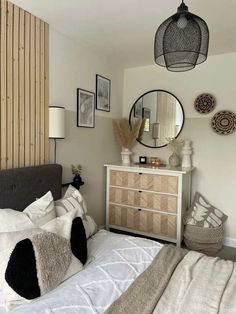 a bedroom with a bed, dresser and mirror