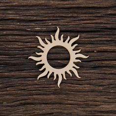 a wooden sun cutout sitting on top of a piece of wood with a hole in the middle