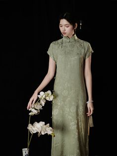 A Chinese dress with a grayish green color that creates a nostalgic atmosphere. It depicts flowers and plants blooming in a bamboo forest, giving it a slightly glossy feel. Enjoy "China" to your heart's content with its gorgeous and bewitching atmosphere. 
 
 ＜Size＞ 
 
 S size 
 
 Length: 115cm 
 Bust: 84cm 
 Waist: 80cm 
 Hip: 94cm 
 Sleeve length: 21.5cm 
 
 M size 
 
 Length: 117cm 
 Bust: 88cm 
 Waist: 84cm 
 Hip: 98cm 
 Sleeve length: 22.5cm 
 
 L size 
 
 Length: 119cm 
 Bust: 92cm 
 Waist Green Spring Wedding Cheongsam, Spring Wedding Green Cheongsam, Green Dresses For Tea Ceremony, Vintage Green Dress With Floral Embroidery, Green Long Ao Dai For Summer, Vintage Long Green Dress, Bamboo Grove, Velvet Evening Dress, Green Bamboo