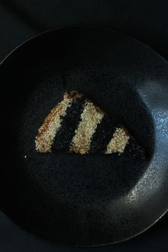 a slice of cake on a black plate with white and black stripes in the middle