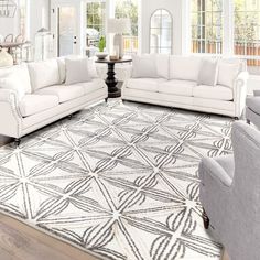 a living room filled with white furniture and lots of windows