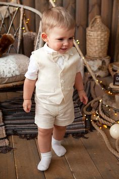 a little boy that is standing up in some kind of suit and bow tie on