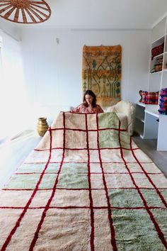 a woman sitting on top of a bed under a blanket