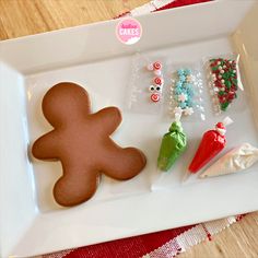 a cookie shaped like a ginger sitting on top of a white plate next to candy