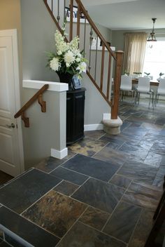 there is a vase with flowers in it on the counter next to the stair case