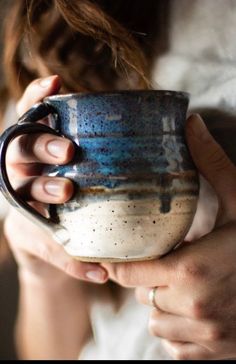 a woman holding a coffee mug in her hands