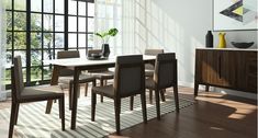 a dining room table and chairs in front of a large window