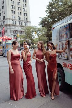 three women in red dresses standing next to a food truck