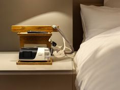 a bed with a lamp and phone on it next to a night stand in the shape of a telephone