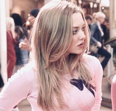 a woman with long hair standing in front of a crowd