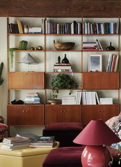 a living room filled with lots of furniture and bookshelves on top of it