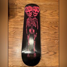 a skateboard with a skeleton painted on it sitting on top of a wooden floor