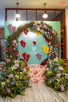 a floral display in front of a blue wall with flowers and butterflies on the side