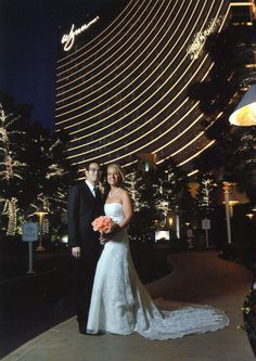 a bride and groom pose in front of the mgm hotel at night, las vegas