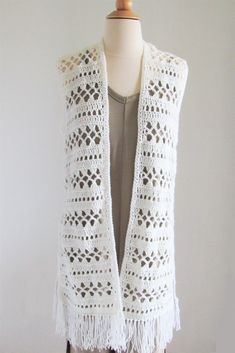 a white crocheted vest on a mannequin