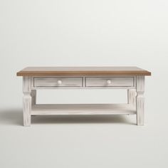 a white coffee table with two drawers