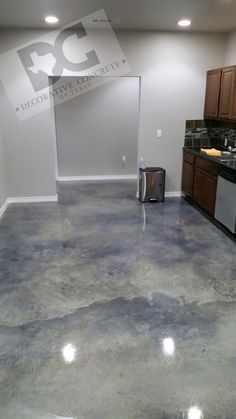 an empty kitchen and living room with granite flooring in the middle of the room