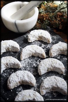 powdered sugar cookies are arranged on a baking sheet