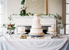 a wedding cake sitting on top of a table next to a white fire place mantle