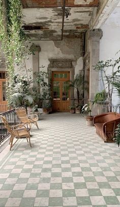 an old building with some chairs and plants in it