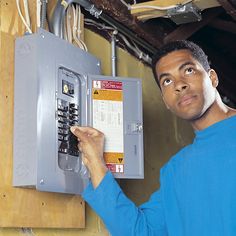 a man is looking up at an electrical panel