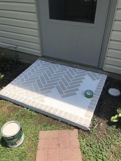 a white door sitting on top of a cement slab next to a green paint can