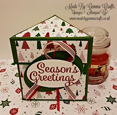 a christmas card with a jar of jam on the table next to it and an envelope that says season's greetings