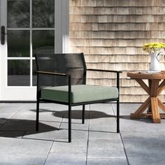 a chair sitting on top of a patio next to a table