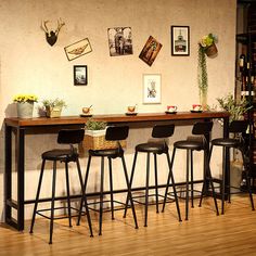 four stools and a table with pictures on the wall