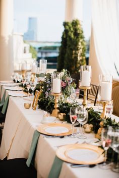 the table is set with candles, plates and wine glasses for an elegant wedding reception