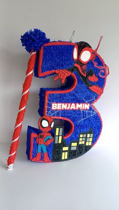 a cake shaped like the number five with spiderman on it