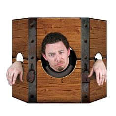 a man is peeking out from behind a wooden box