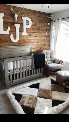 a baby's room with a deer head on the wall and wooden paneled walls