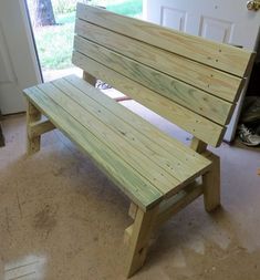 a wooden bench sitting in the middle of a living room next to a garage door