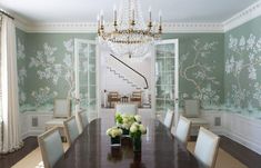 an elegant dining room with green walls and floral wallpaper