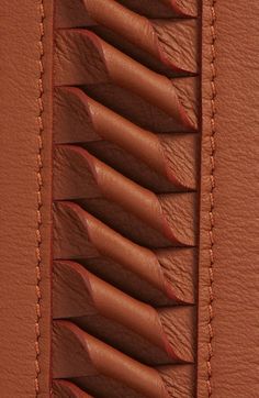 the inside of a brown leather case with several rows of curved sections on top of it