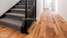 an empty hallway with stairs and wood flooring