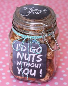 a jar filled with nuts sitting on top of a pink and white polka dot tablecloth